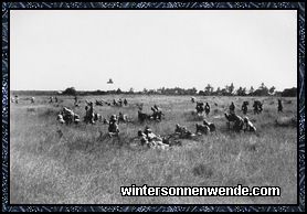 Mit Maschinengewehr und Munition vorgehende deutsche Askaris.